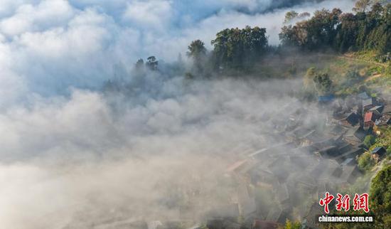 初冬时节，贵州省黔东南苗族侗族自治州榕江县兴华乡摆贝村出现云海景观，浩瀚的云海在连绵起伏的山峦间翻涌，宁静的村庄掩隐在云海群山中，构成了一幅人与自然和谐共生的生态画卷。图为榕江县摆贝村“云上苗寨”景观。（无人机照片）尹刚 摄